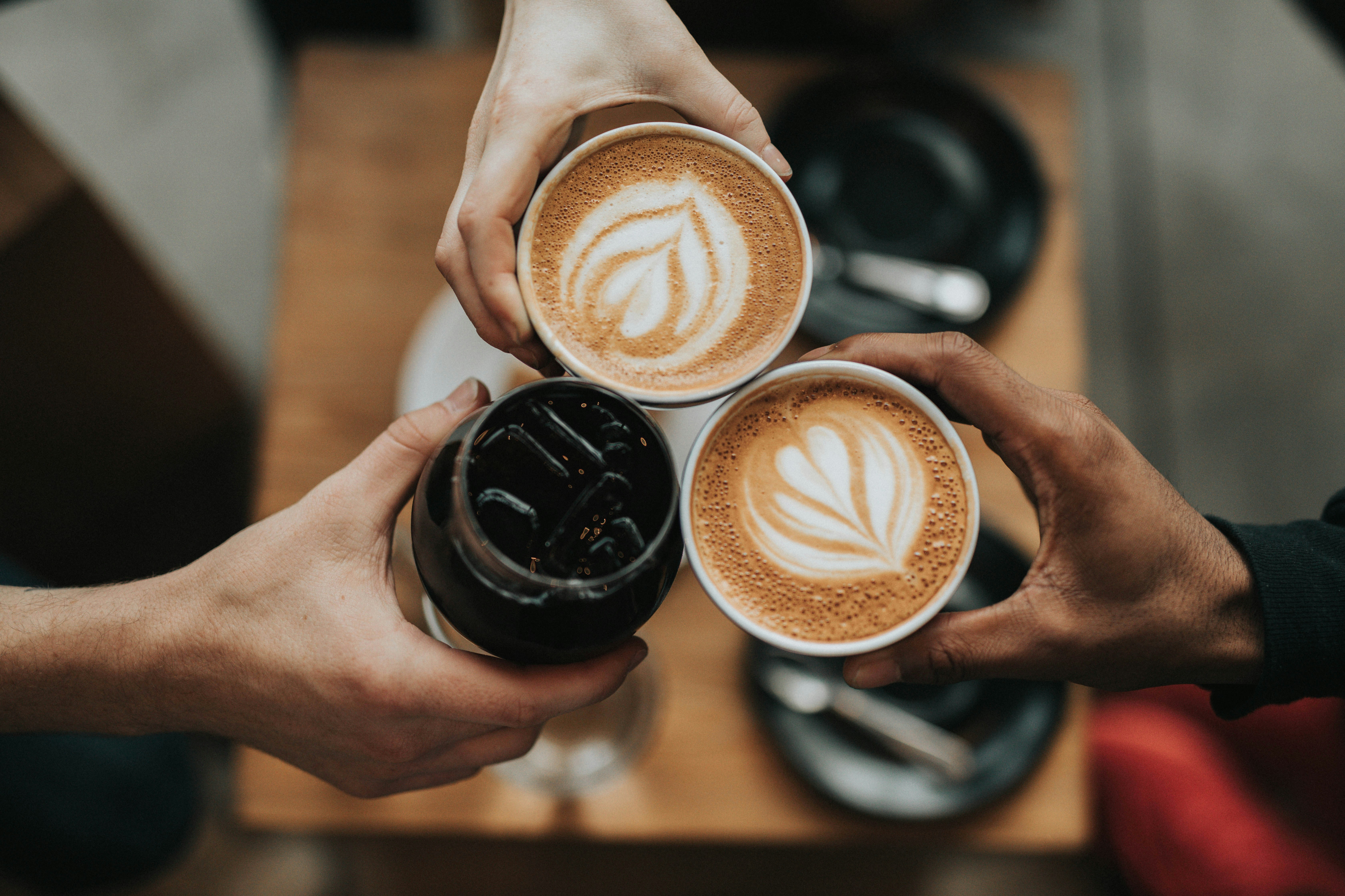 three friends holding coffee drinks