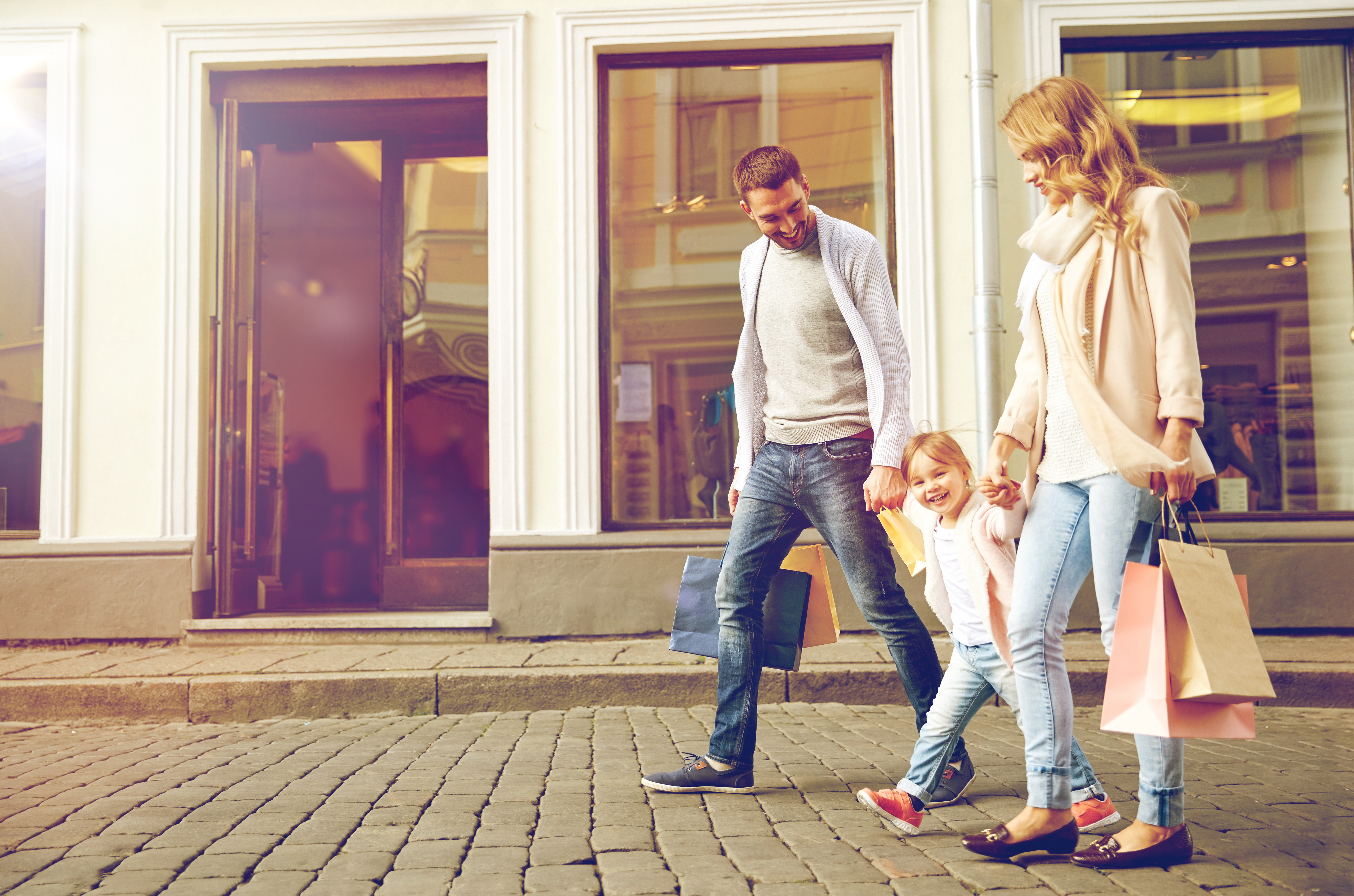 sale, consumerism and people concept - happy family with little child and shopping bags in city