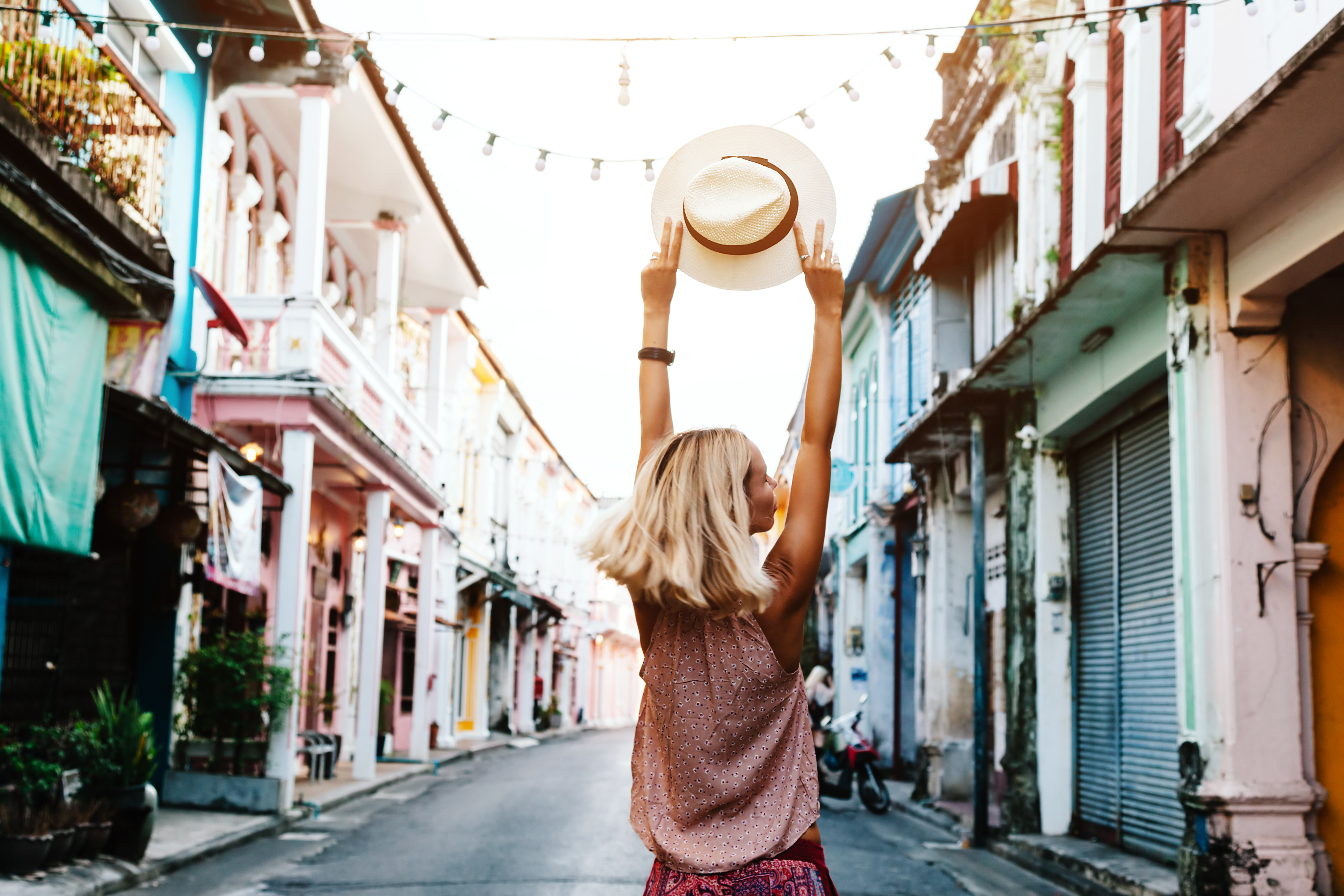 Boho girl walking on the city street. Travelling in Phuket Old Town in Thailand.