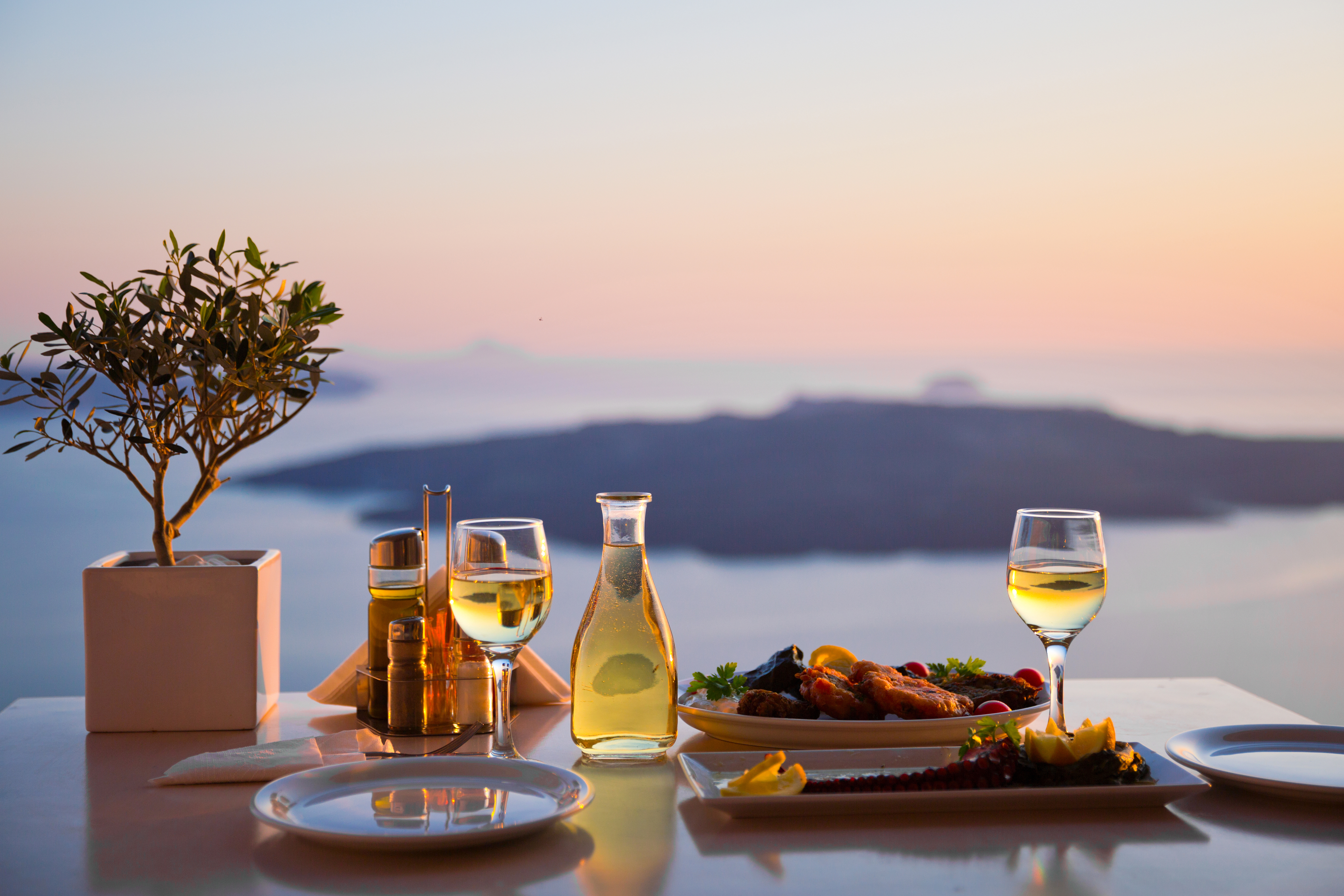 Romantic dinner for two at sunset.Greece, Santorini, restaurant on the beach, above the volcano.