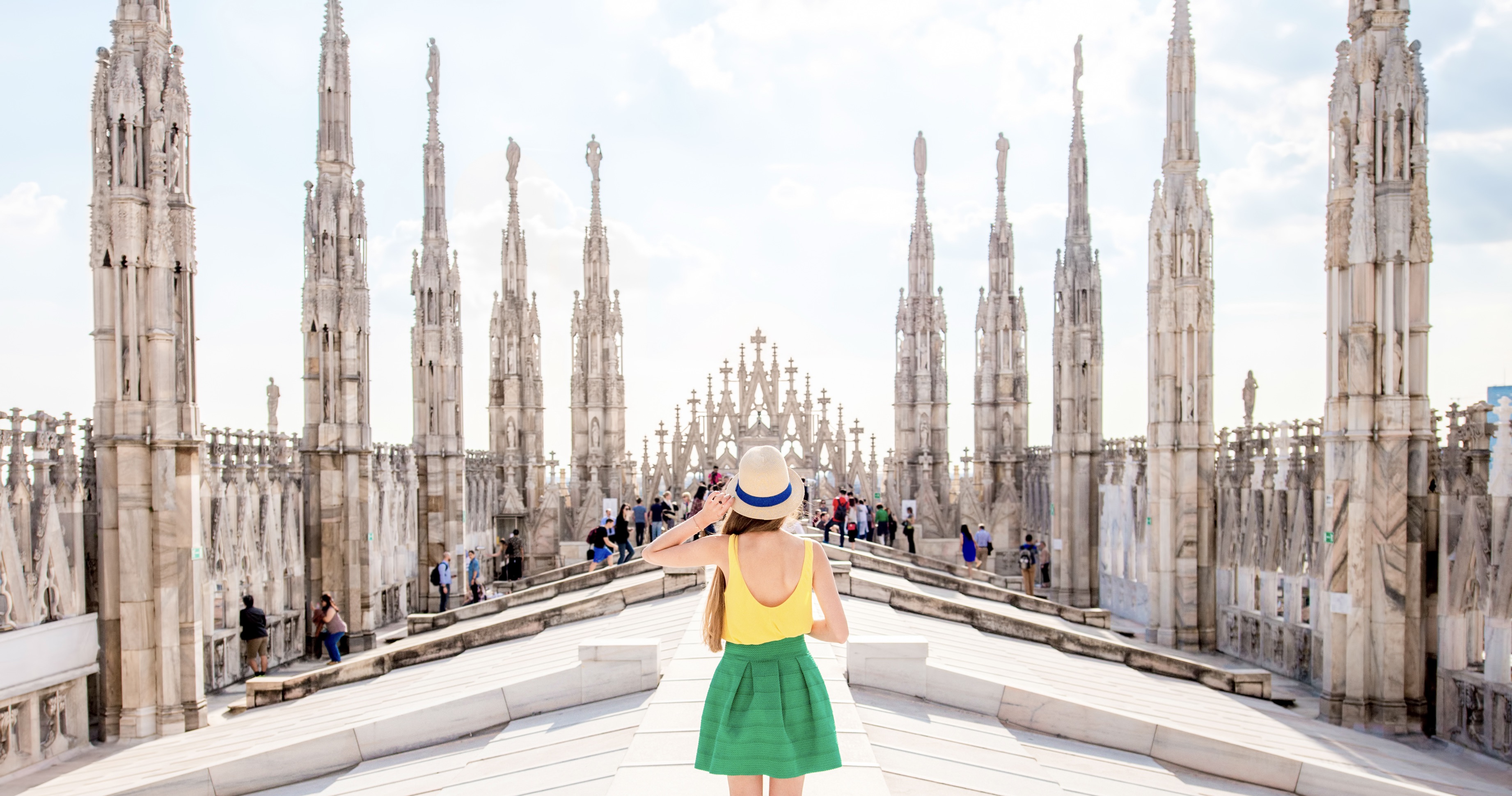Back view on the female traveler standing on the rooftop of Duomo cathedral in Milan