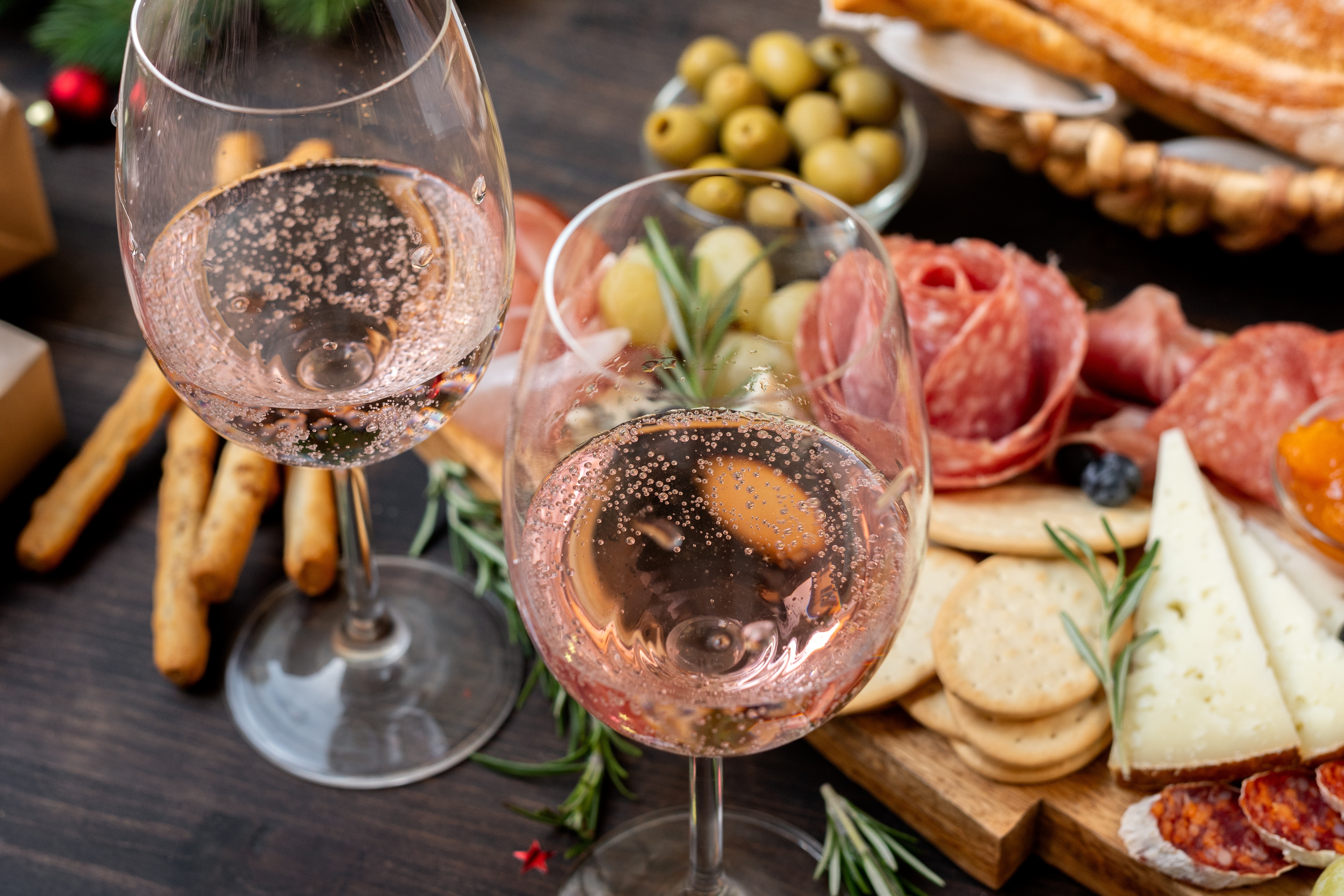 festive aperitif or party two glasses of champagne, Prosecco or rosé wine with cold meat appetizers cheeses and olives