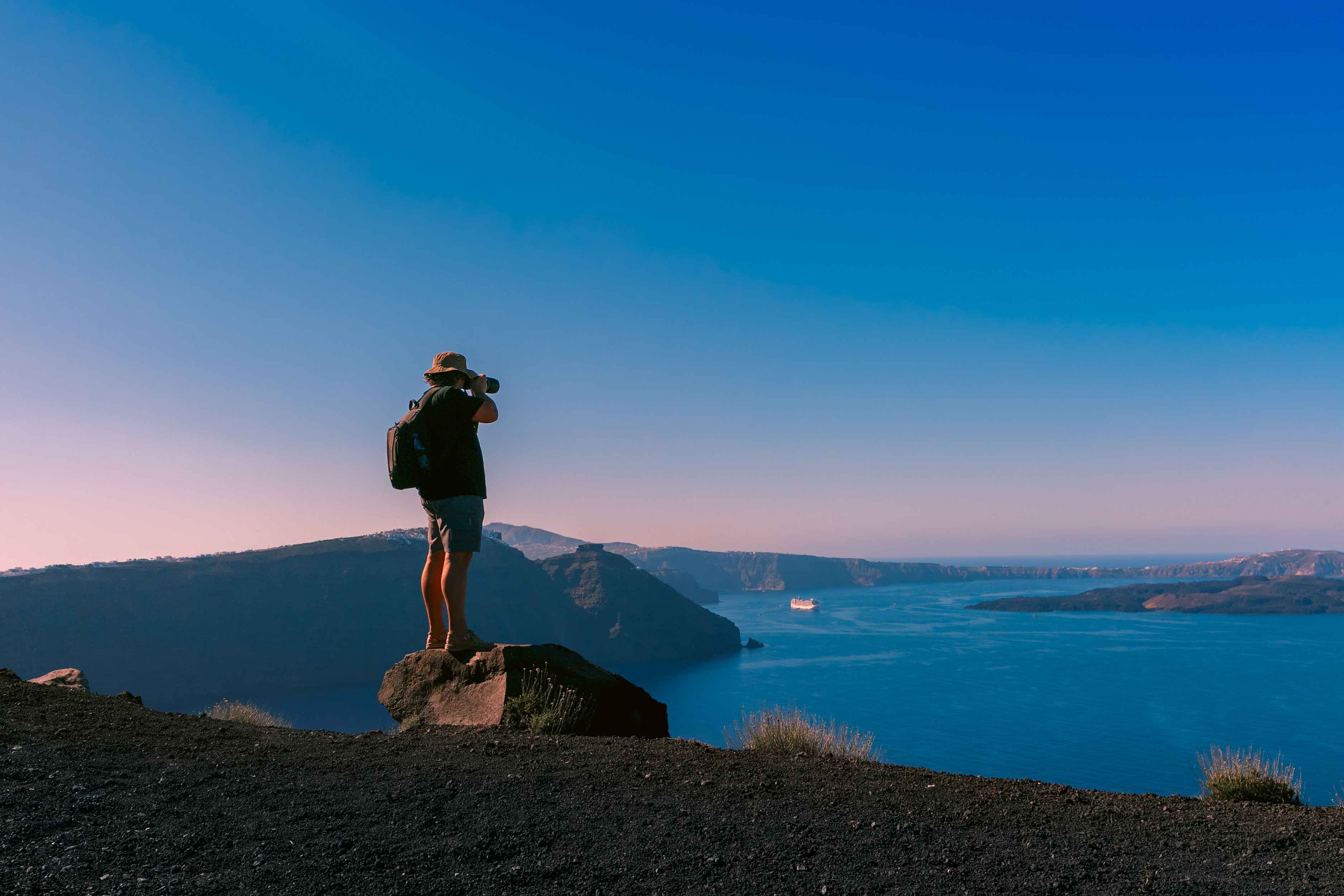 Photographer traveler takes picture caldera and Santorini island in Aegean sea, Greece