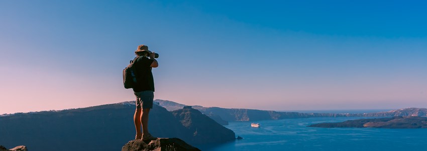 Photographer traveler takes picture caldera and Santorini island in Aegean sea, Greece
