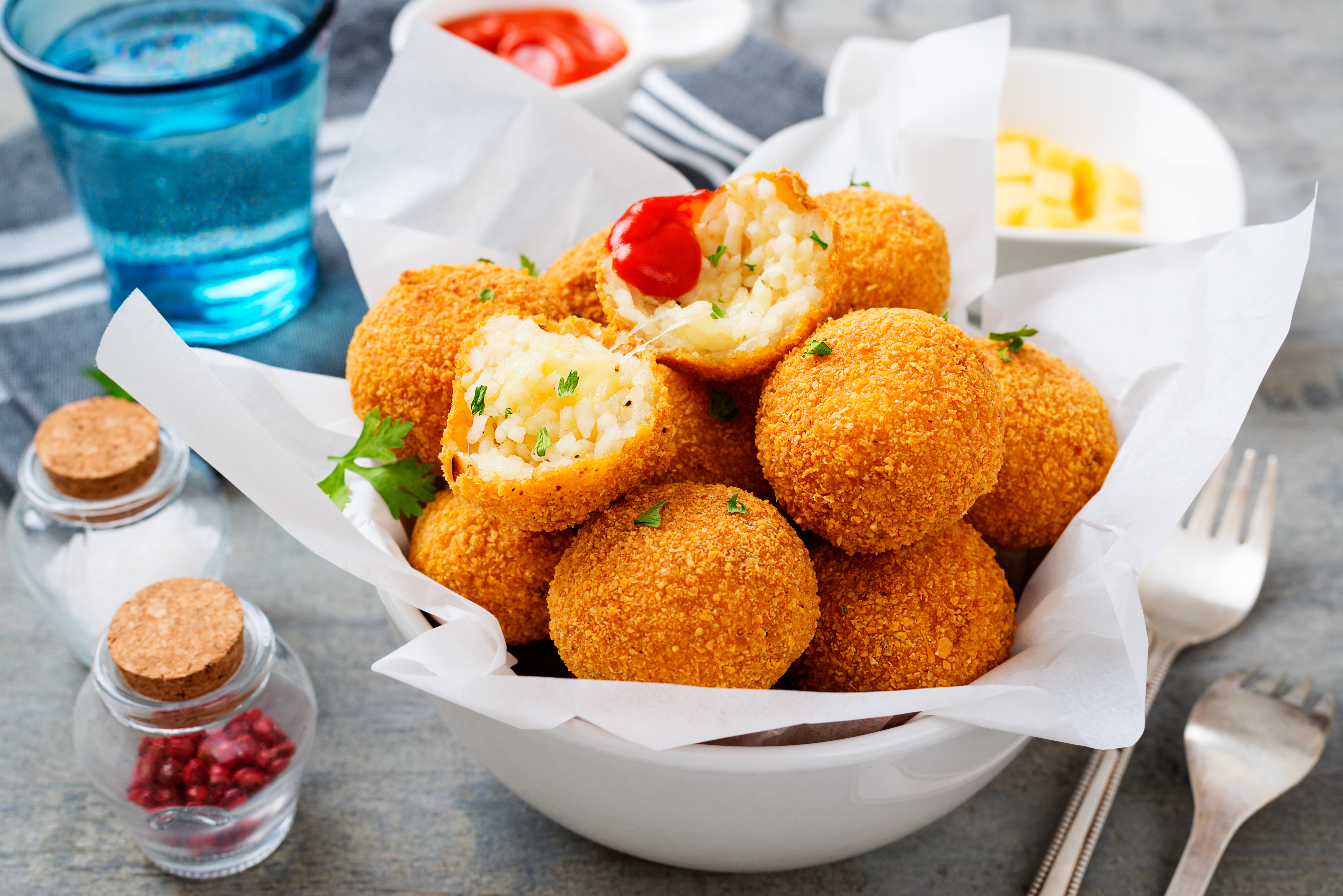 Homemade Fried Risotto Arancini stuffed with cheese, served with tomato sauce.