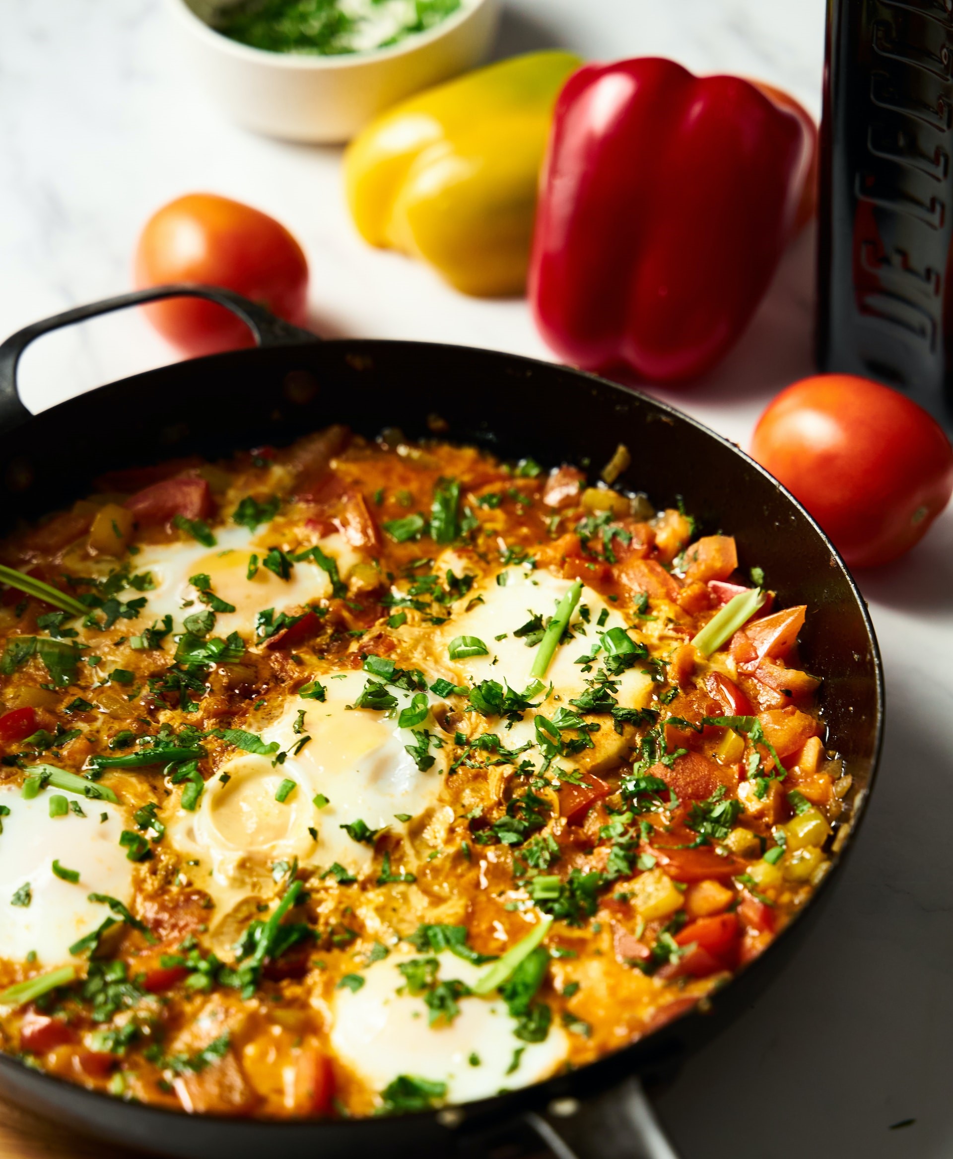 shakshuka in skillet with tomatoes and bell pepper