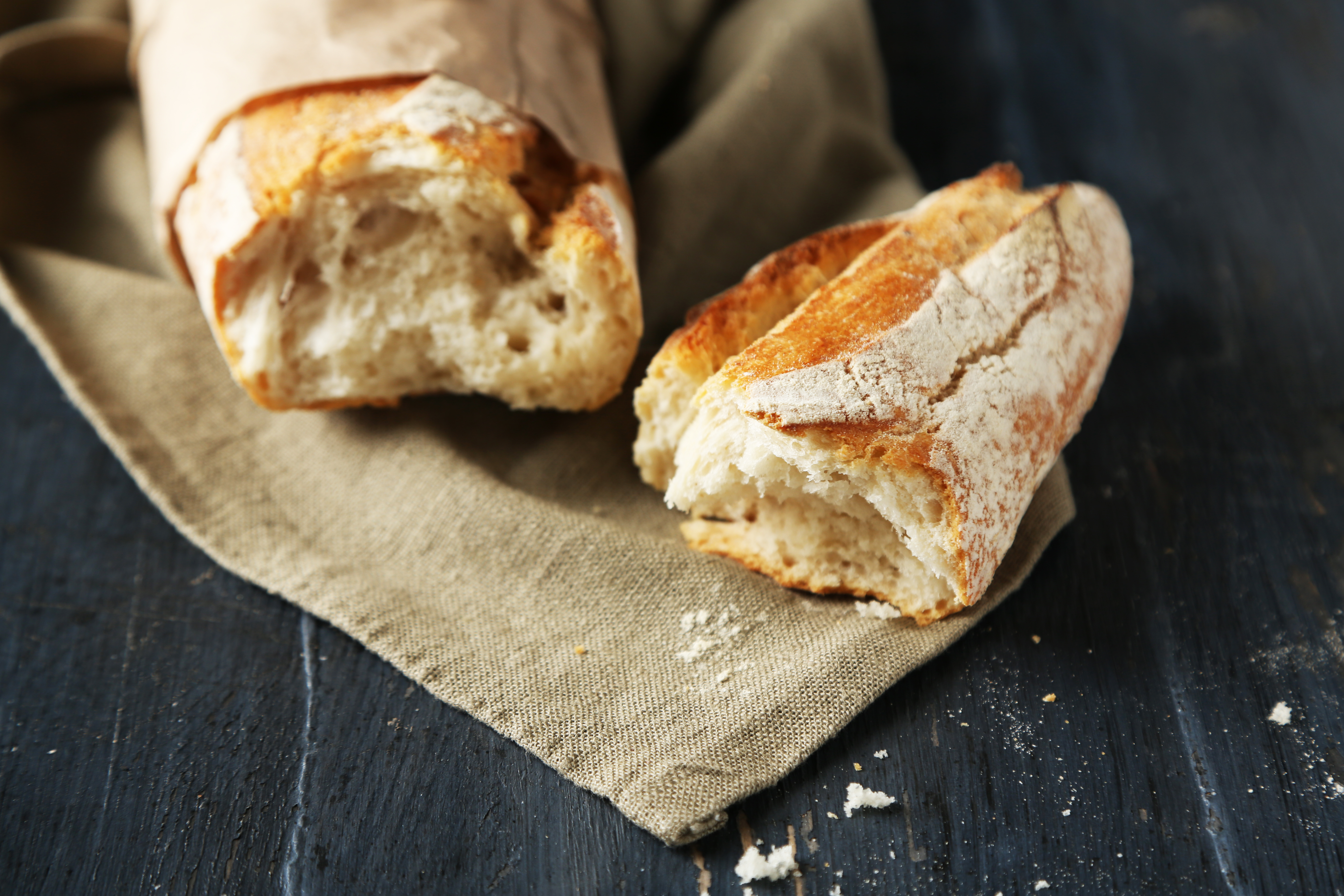 Fresh baguette on wooden table, close up