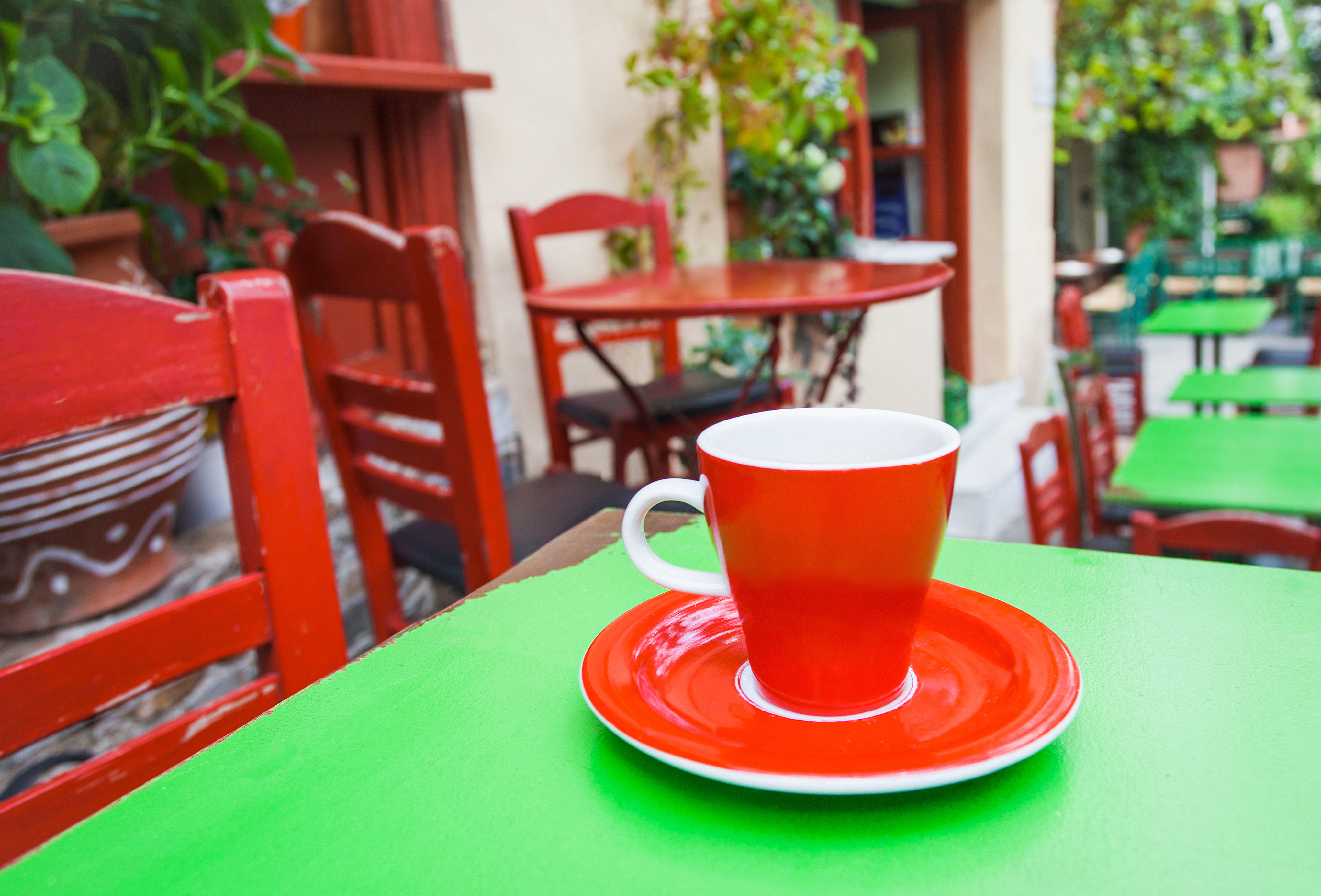 A cup of coffee on table with old street at the background, Southern Europe