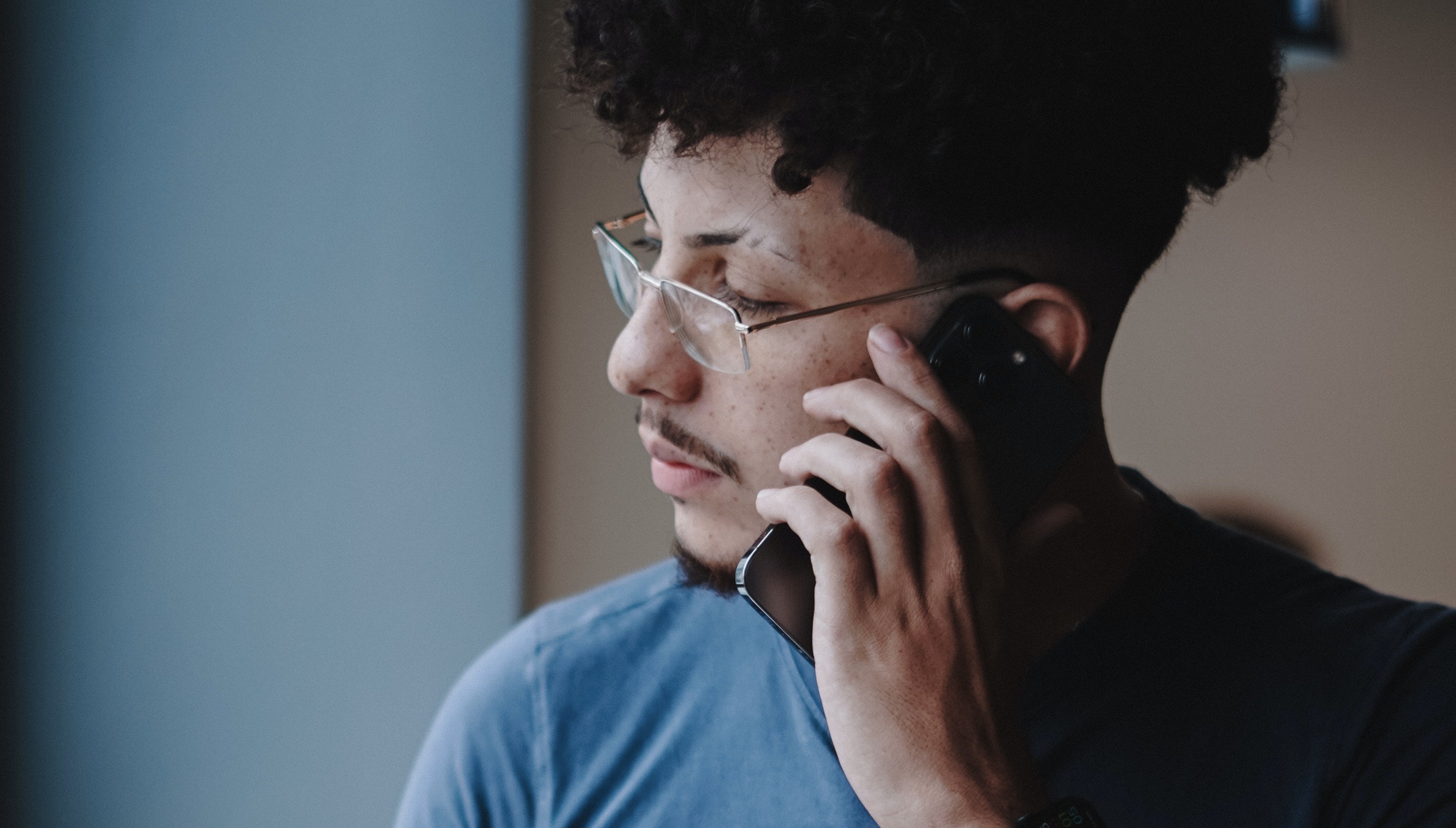 Man Working on Laptop Talking on Cellphone