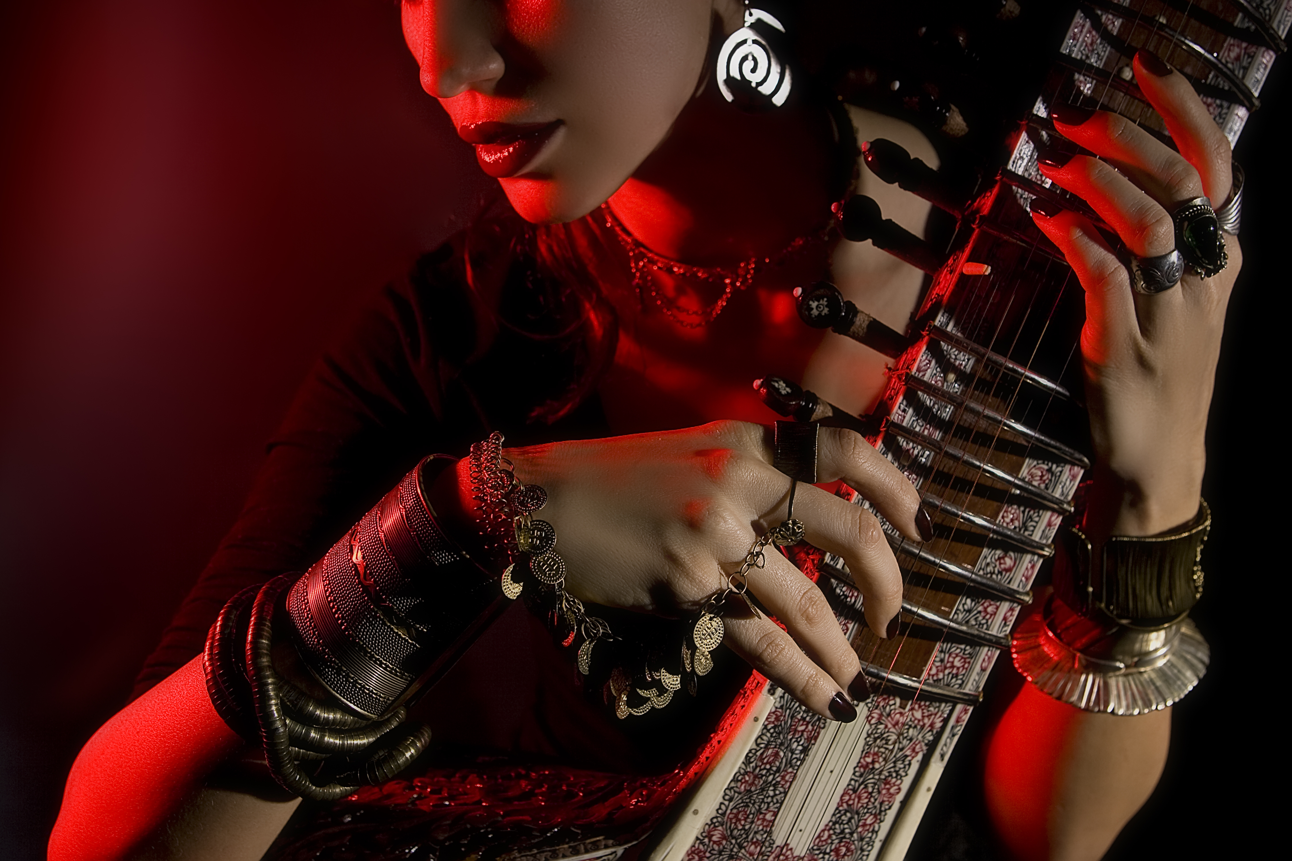 indian woman in traditional clothing with sitar and oriental jewelry