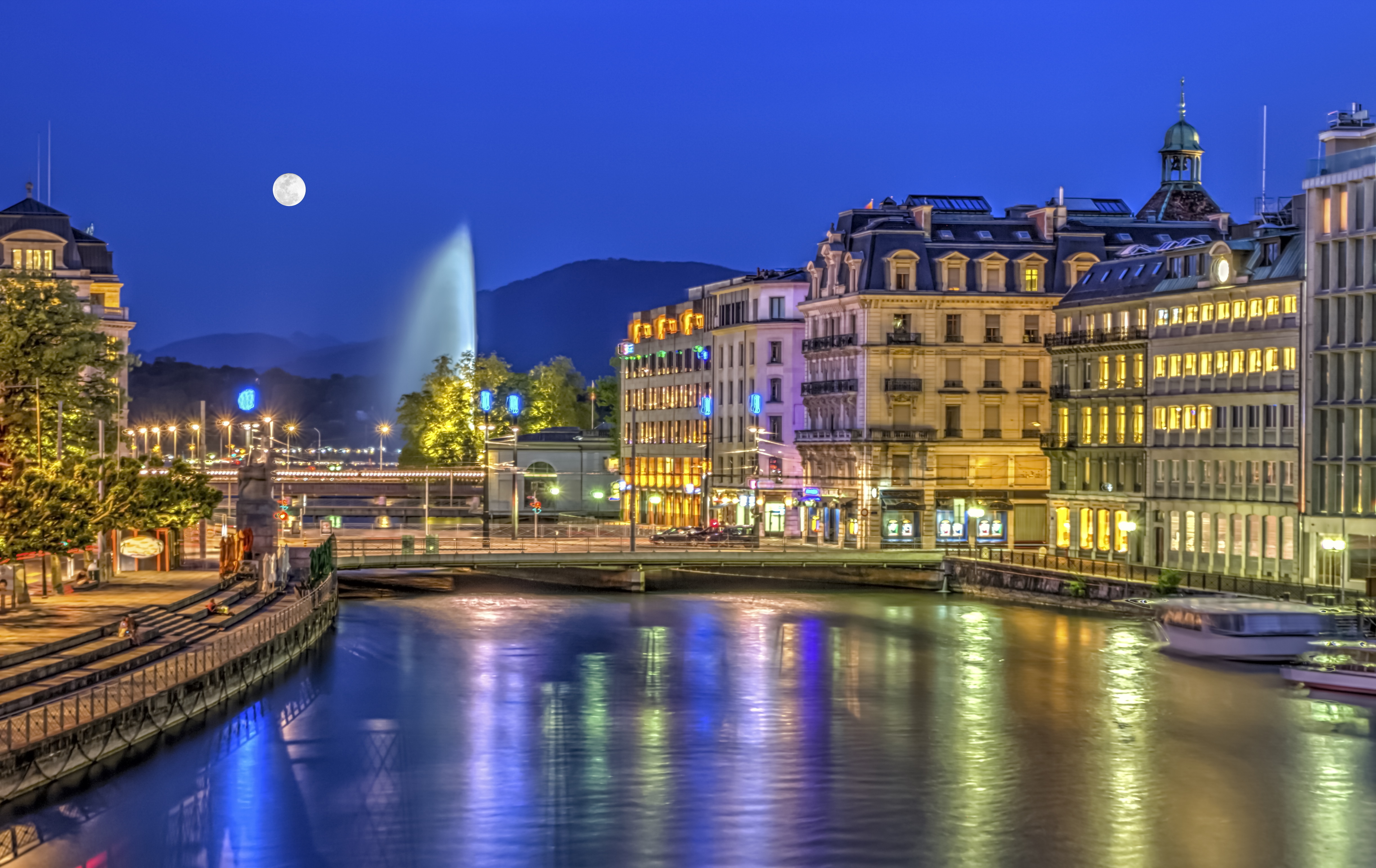 Urban view with famous fountain by night with full moon, Geneva, Switzerland, HDR