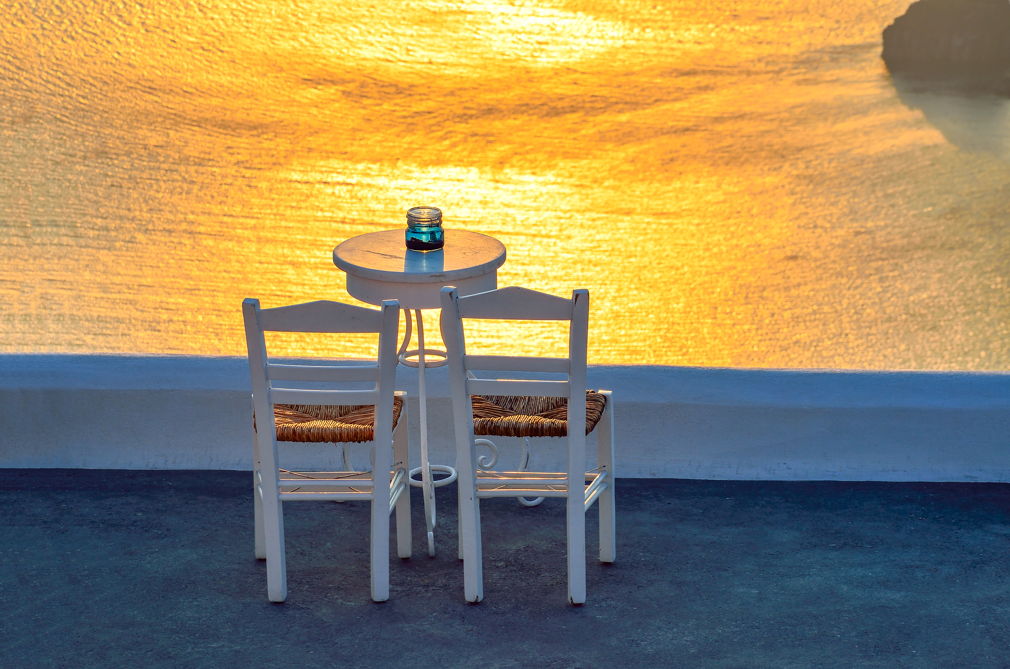 Two chairs and a small table with a wonderful view in Santorini, Greece.