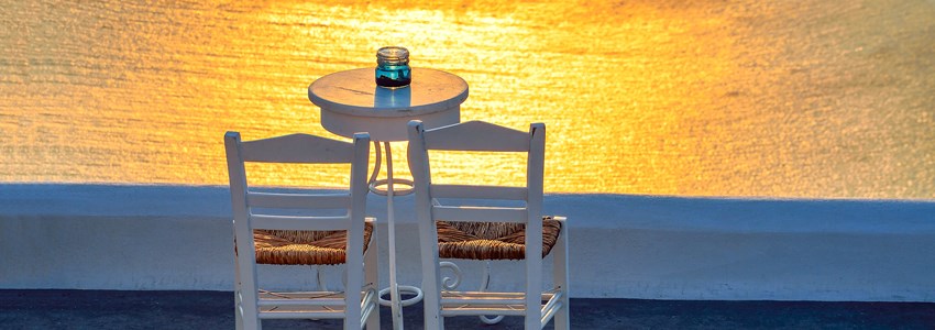 Two chairs and a small table with a wonderful view in Santorini, Greece.