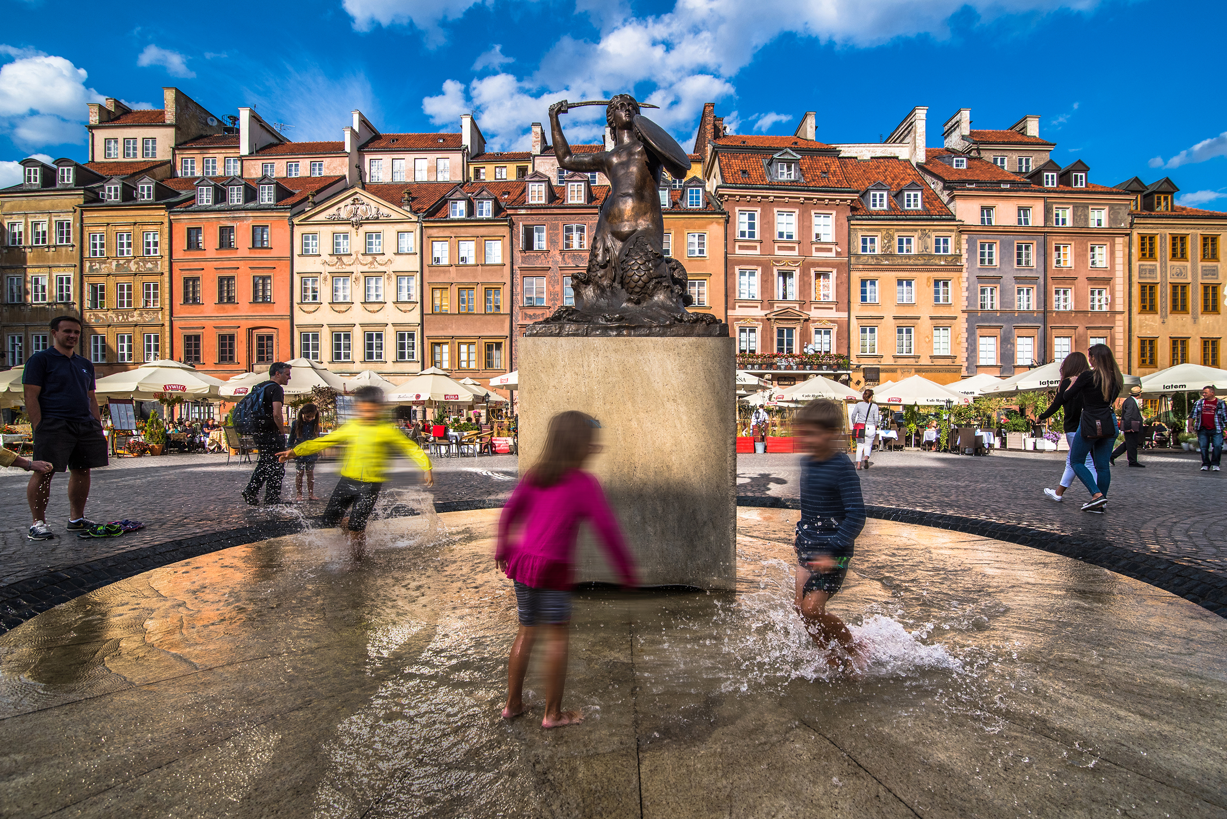 kids playing in front of a statue