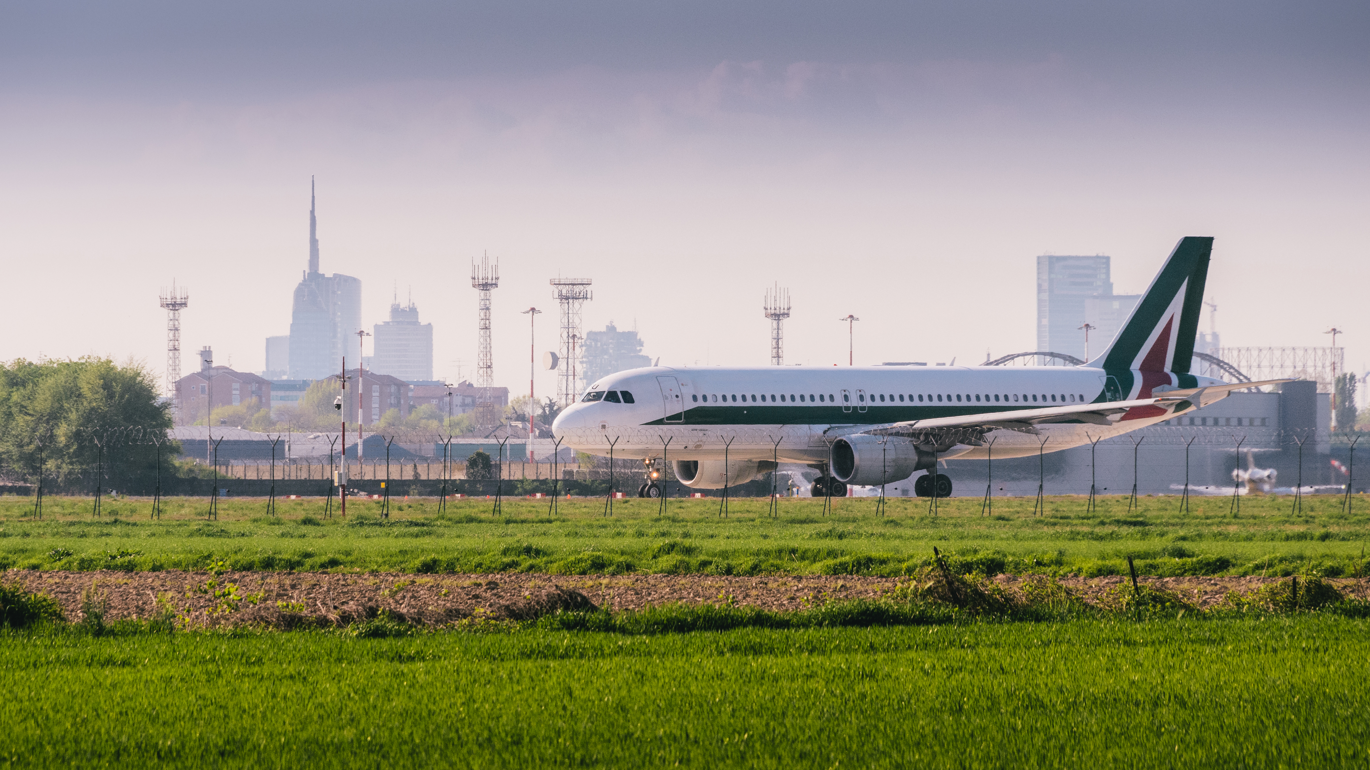 Airplaline at Milan, Italy's Linate airport with Milan's iconic skyline in the background