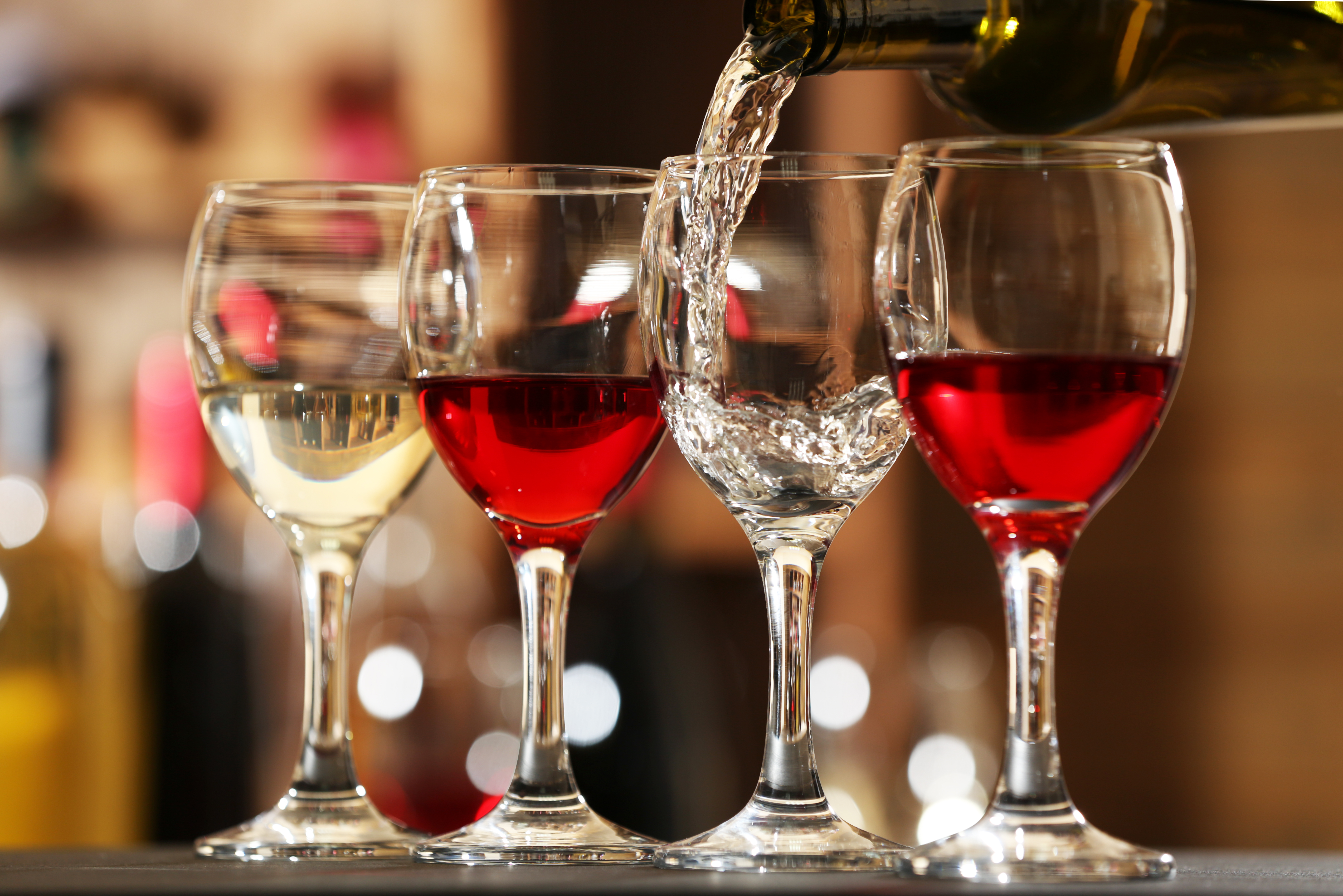White wine pouring into wine glass, closeup