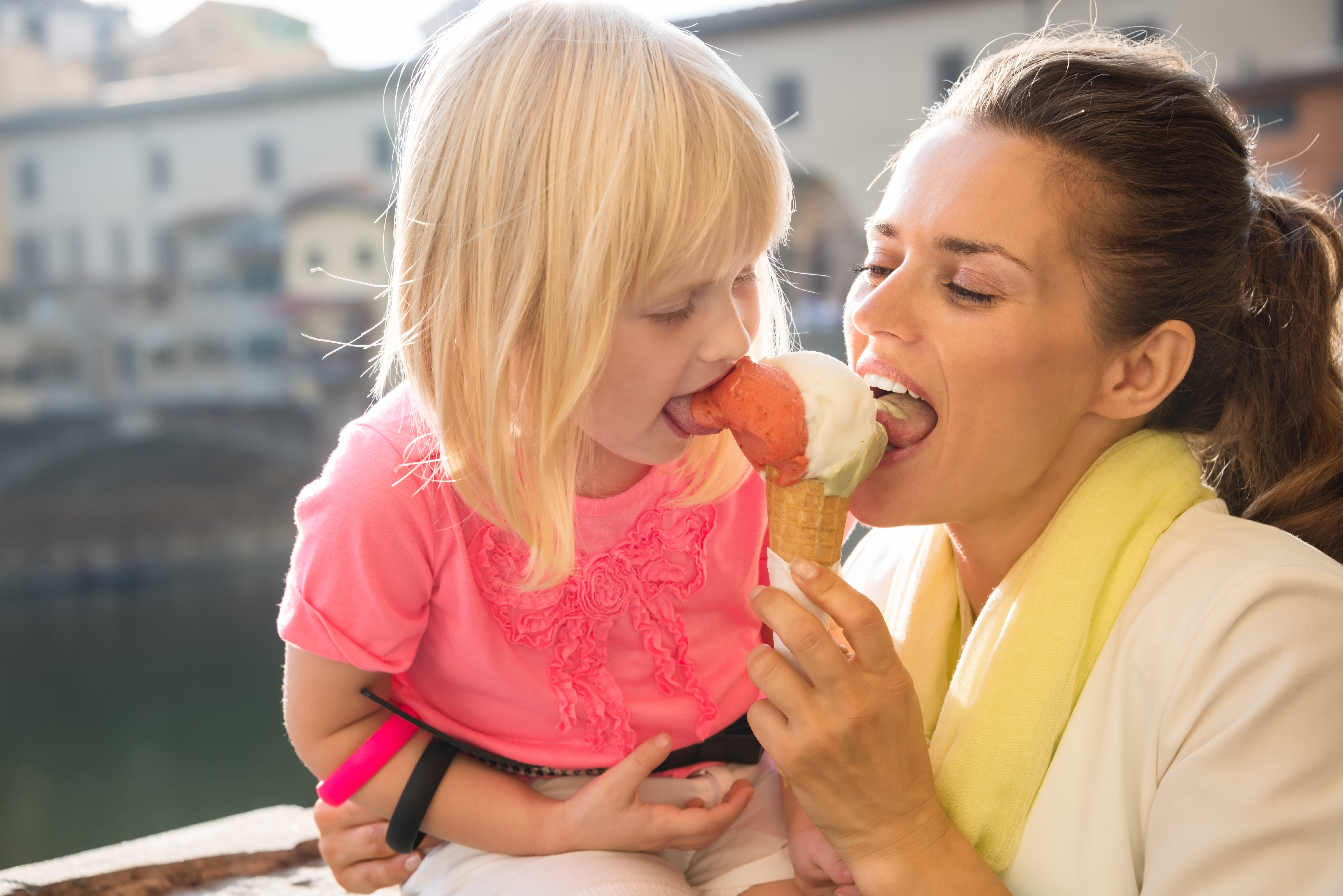 Family discovering old Italian treasures in Florence. Portrait of happy mother and daughter eating ice cream near Ponte Vecchio