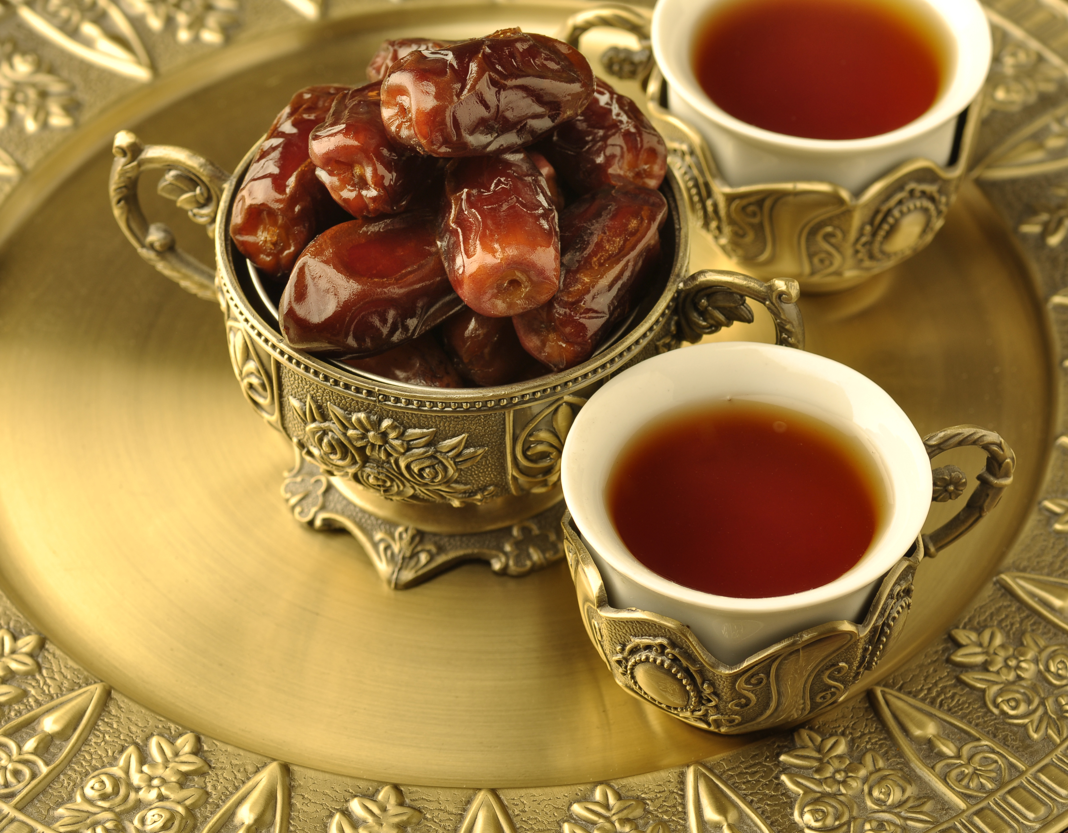 A golden bowl of dates and tea