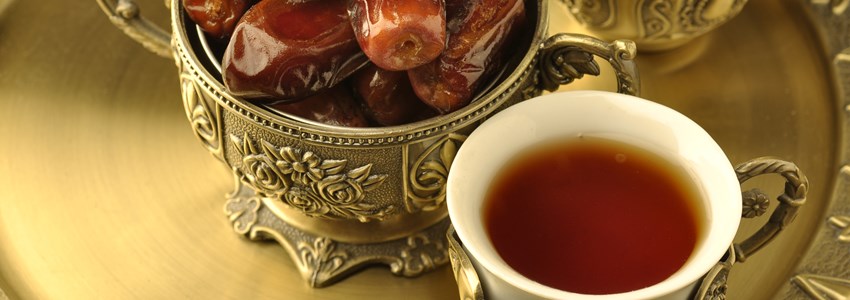 A golden bowl of dates and tea