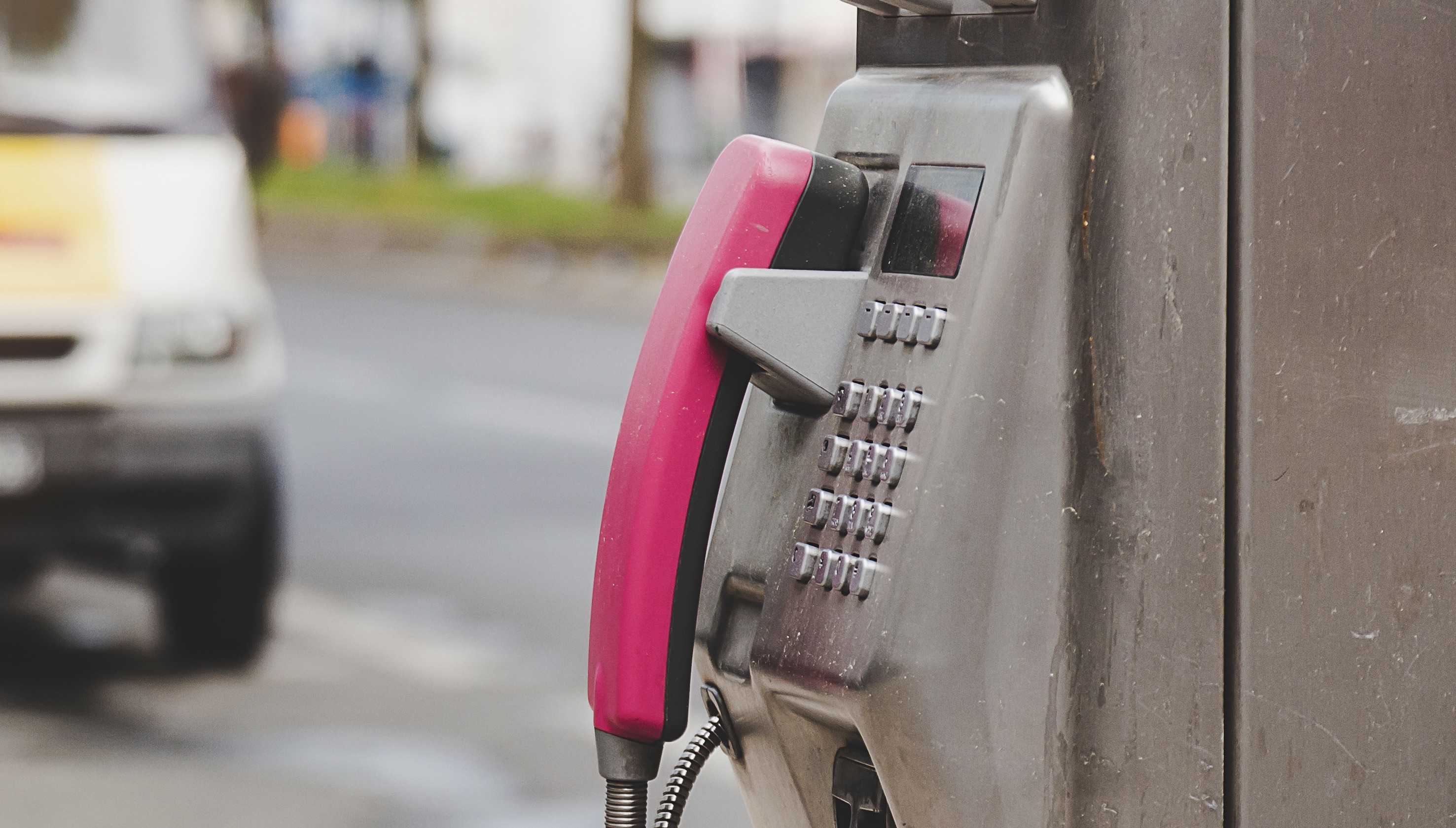 Close up public telephone or payphone beside the road and car van background in Berlin, Germany