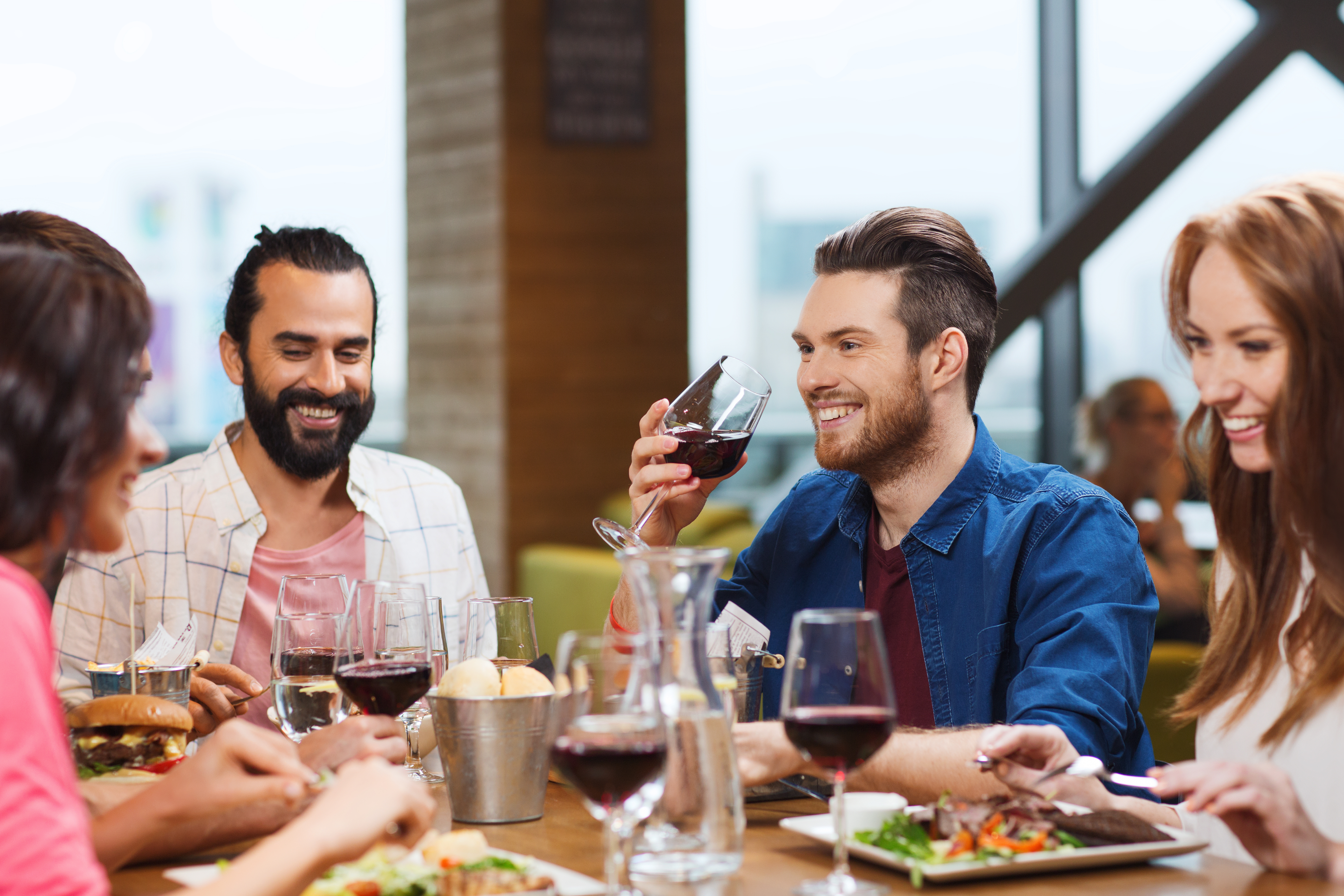 friends dining and drinking wine at restaurant