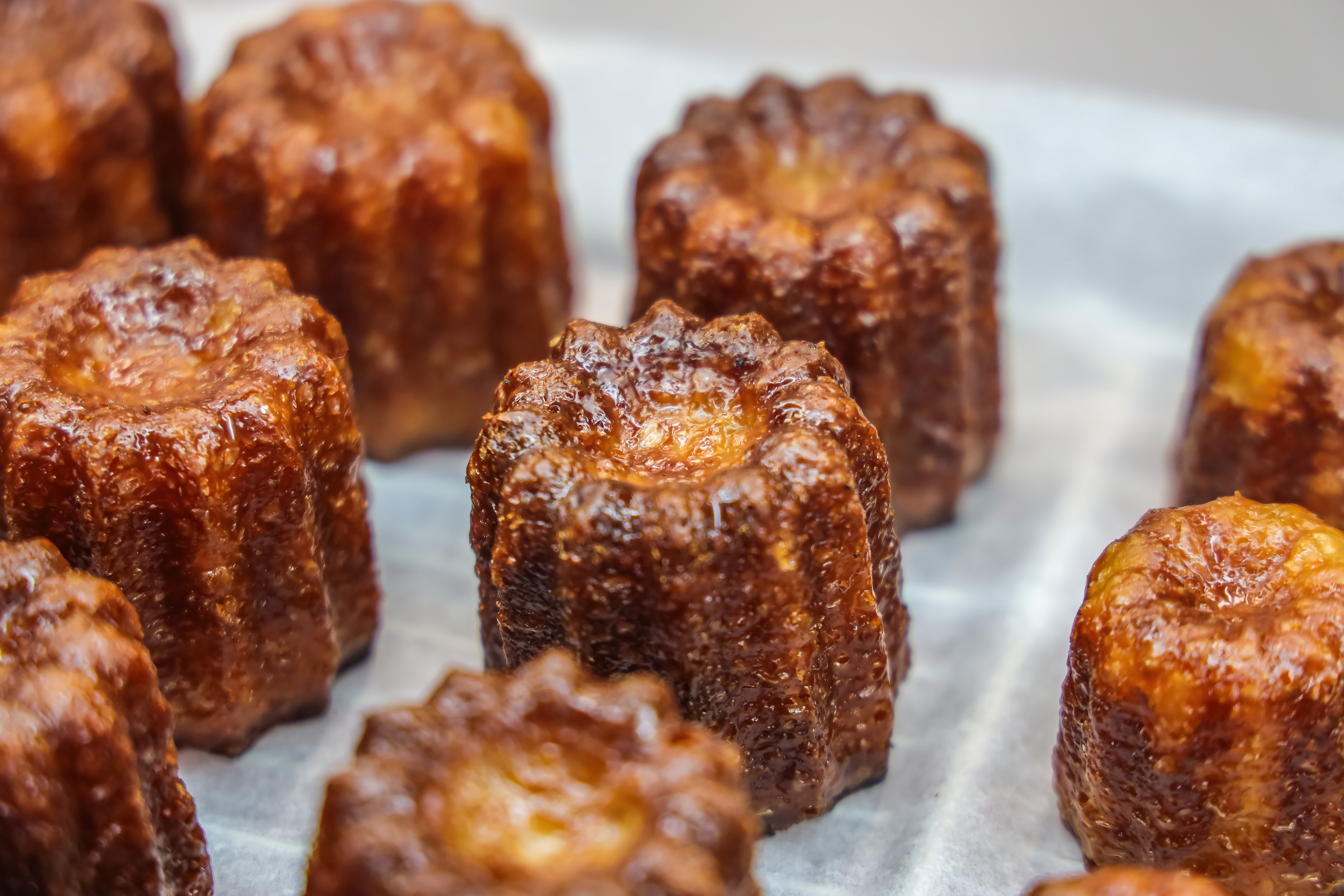 Caneles de Bordeaux. canelé is a small French pastry flavored with rum and vanilla with a soft and tender custard center and a dark, thick caramelized crust.